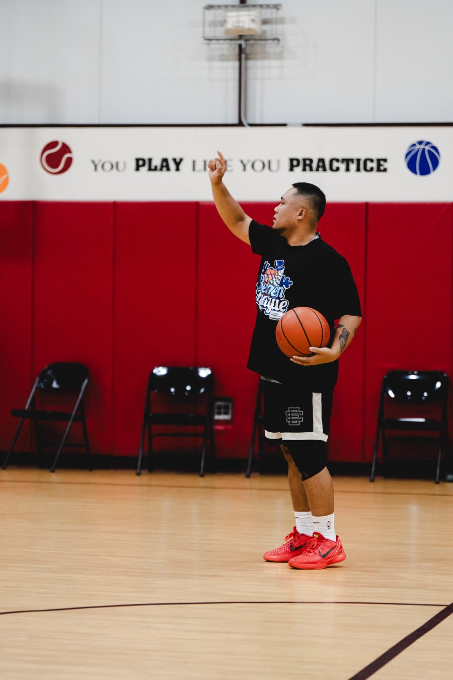 Player pointing at the You Play Like You Practice wall