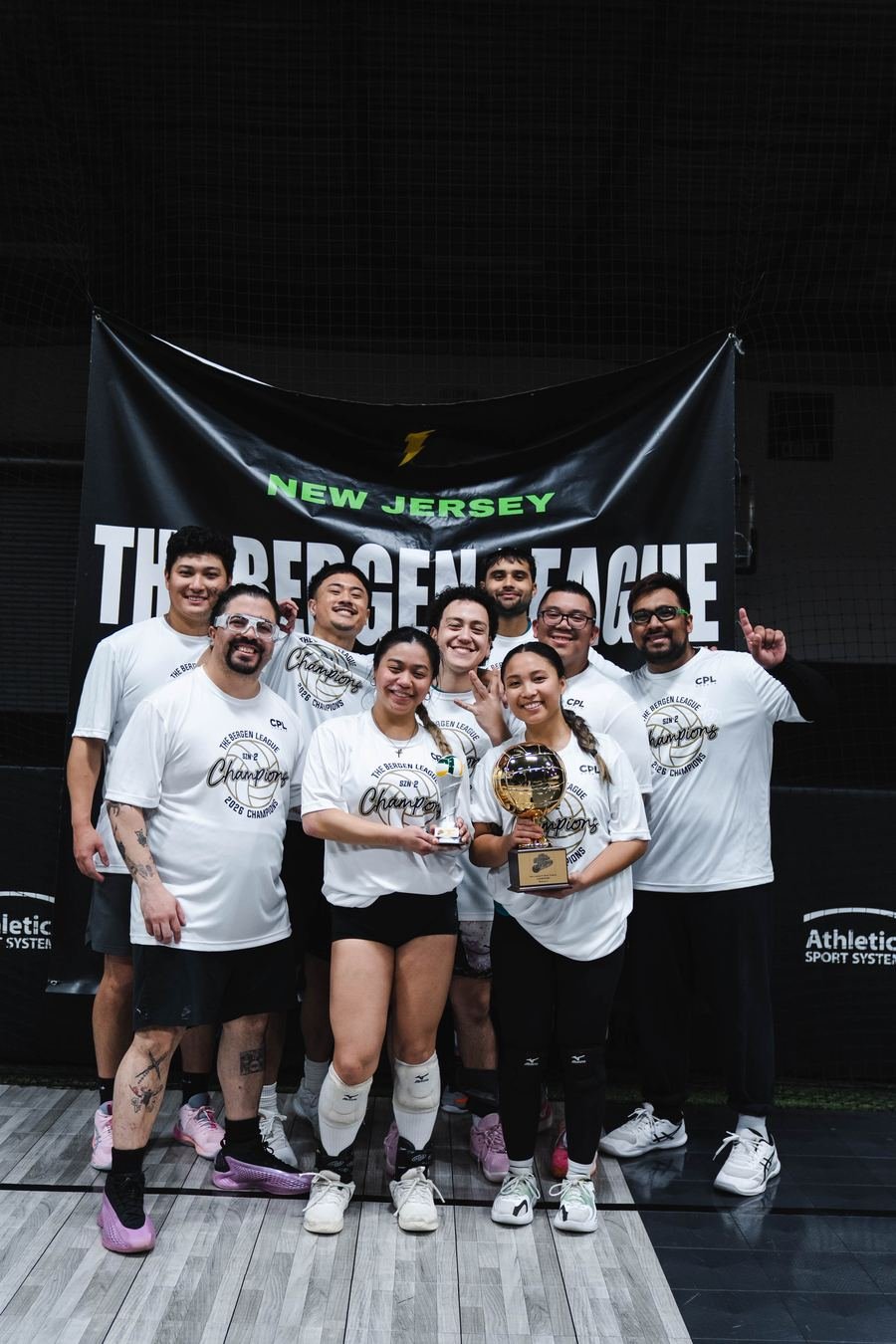 Champions celebrating with volleyball trophy